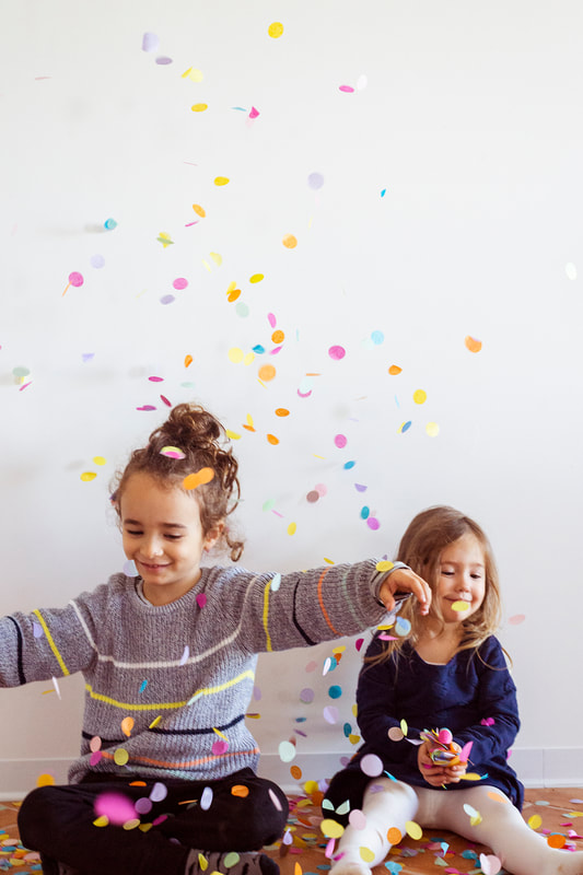 a boy and a girl that are seated through confetti