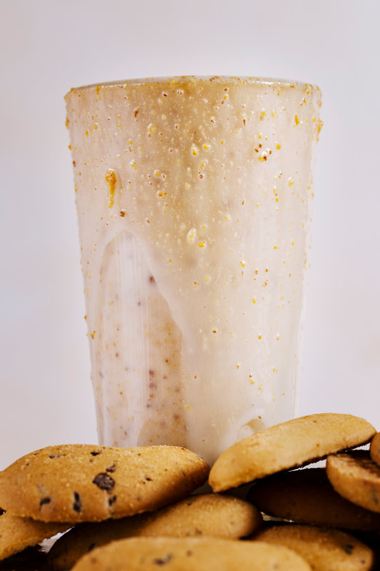Smoothie served in tall glass with chocolate chip cookies.
