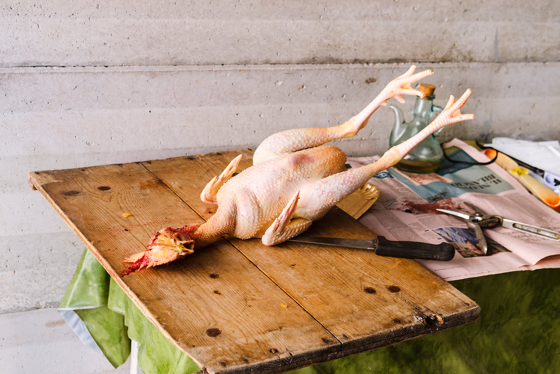 Freshly slaughtered chicken on wooden chopping board