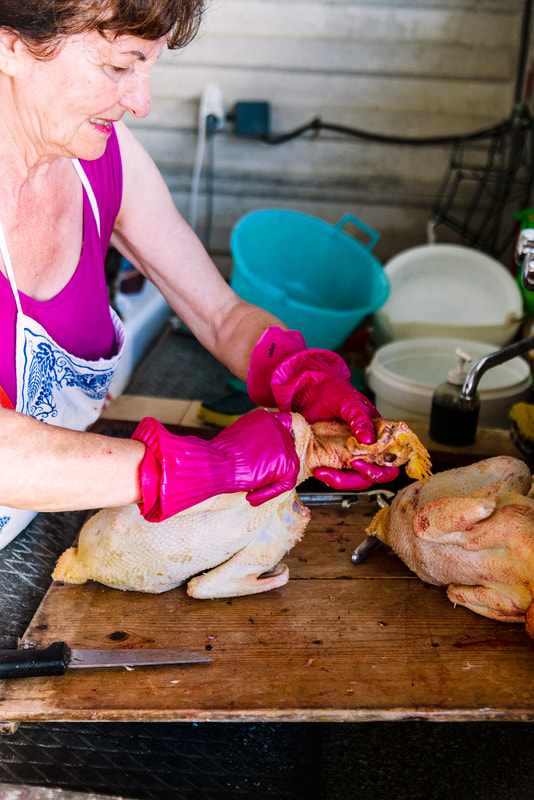 woman cleaning chicken neck.