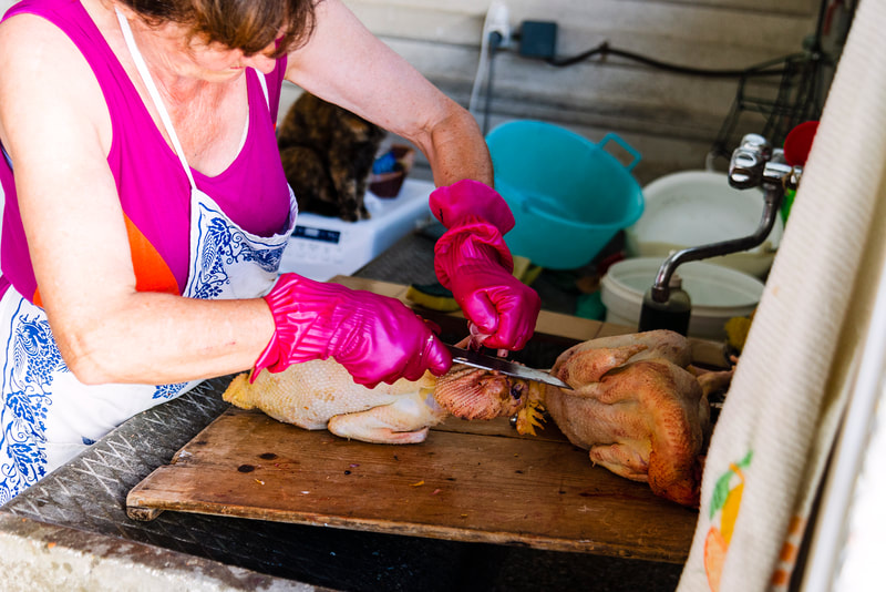 Woman cleaning chicken head.